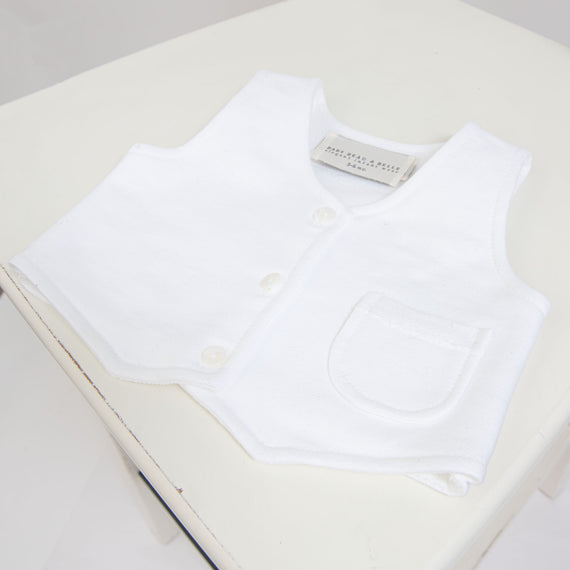 Flat lay photo of the Elliott Vest, made with a white French Terry Cotton with a three button closure and darling pocket detail.