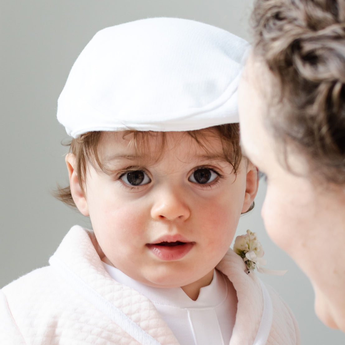 Baby boy with his mother and wearing the White French Terry Newsboy Cap.
