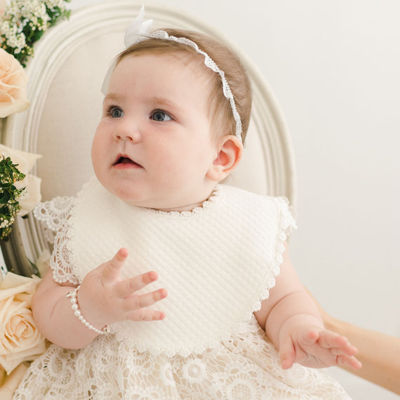 Baby girl wearing the Poppy cotton luxury bib.