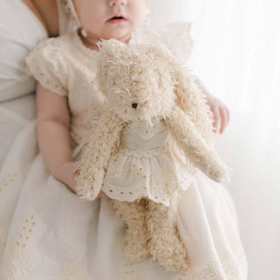 Baby holding a super soft bunny stuffed animal with a matching Ingrid Lace Dress