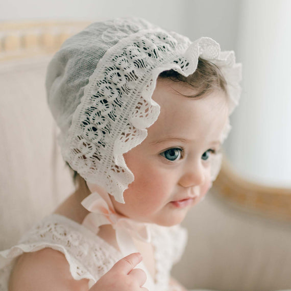 Charlotte cotton lace bonnet with lace ruffle and blush silk ribbon ties.
