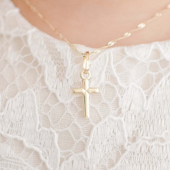 Tiny solid gold cross charm on chain on baby