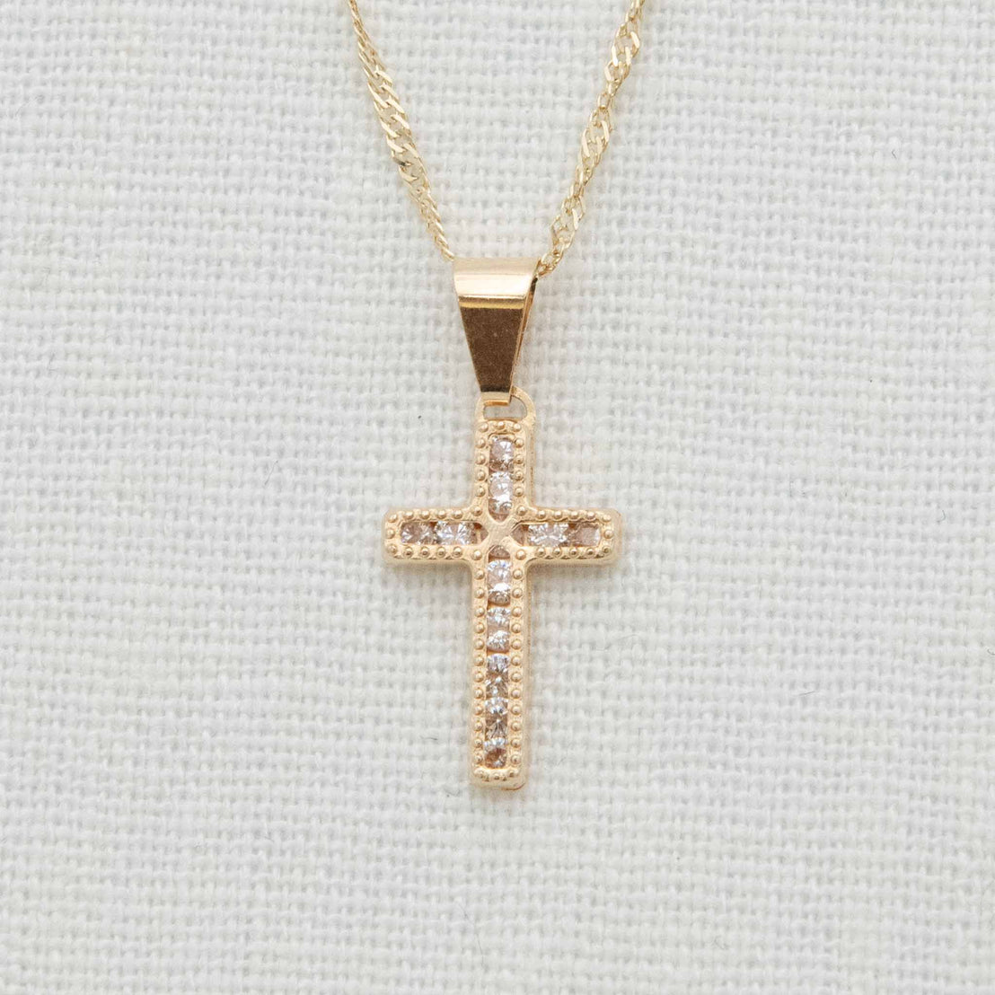 Gold and cubic zirconia cross necklace detail