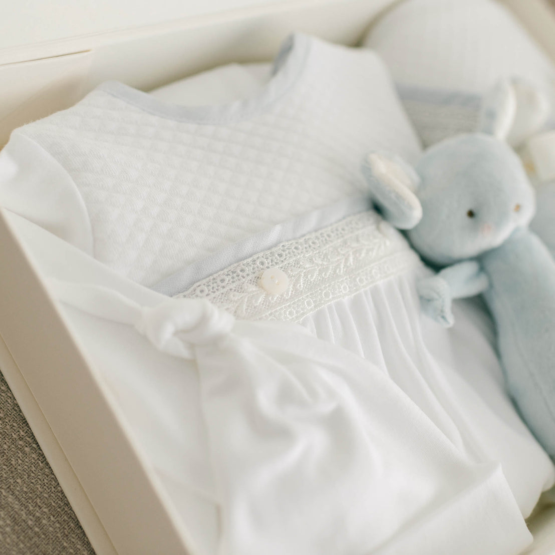 Side view of the Harrison Newborn Gift Set, which includes the Layette Gown, Bonnet (or Knot Cap), Rattle, Blanket, and Gift Box.