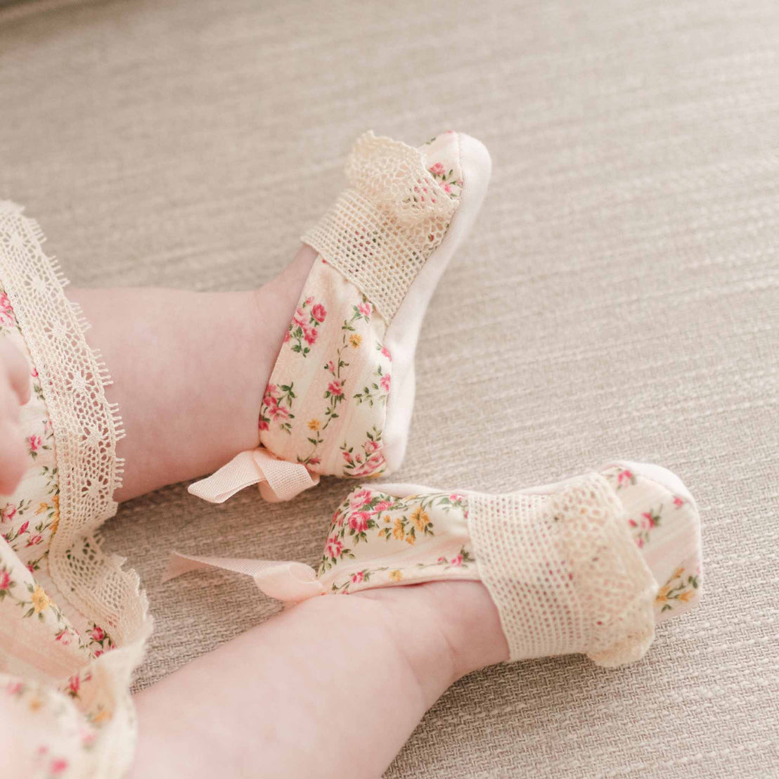 Detail of the "Blush" Eloise Booties made with the matching Eloise floral striped material with natural color lace across the toe and a coordinating cotton ribbon bow on the heel.