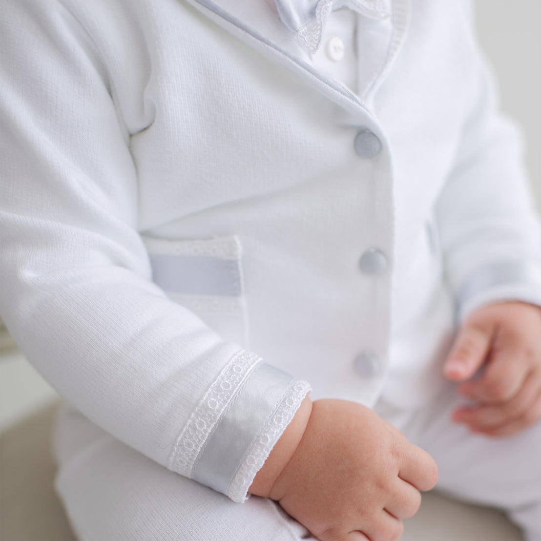 Close-up of a child wearing a white outfit with buttons.