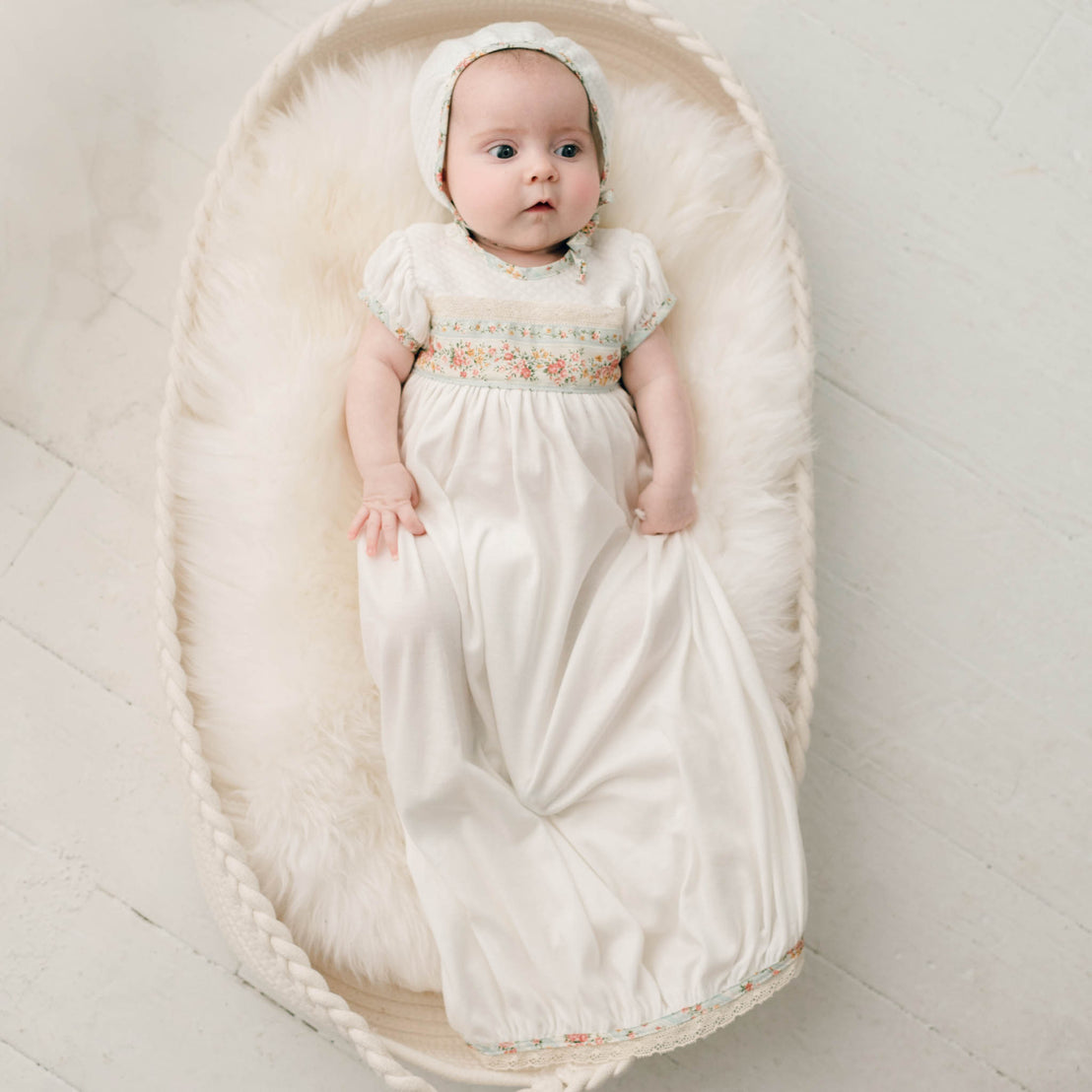 Newborn baby girl wearing the "Powder Blue" Eloise Layette Gown and matching Eloise Bonnet.