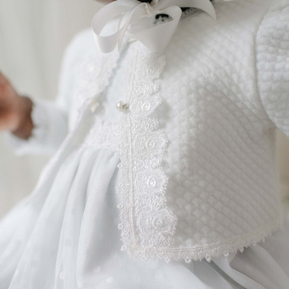 Close-up of a white textured garment with lace detailing