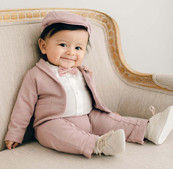 Baby boy sitting in mauve suit and newsboy cap