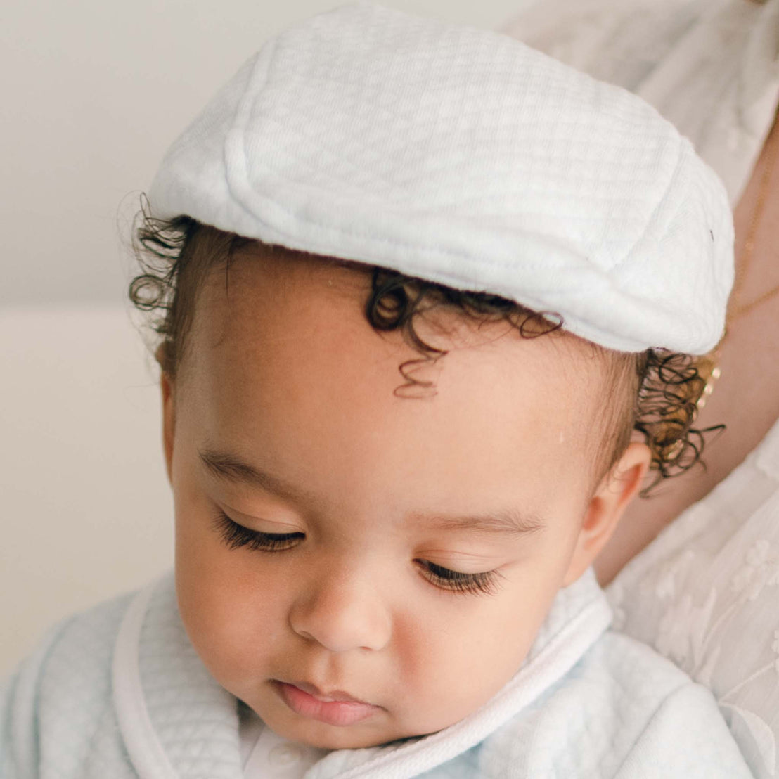 Baby boy wearing the blue Asher Quilted Newsboy Cap made from 100% Quilted Cotton with a soft elastic back.