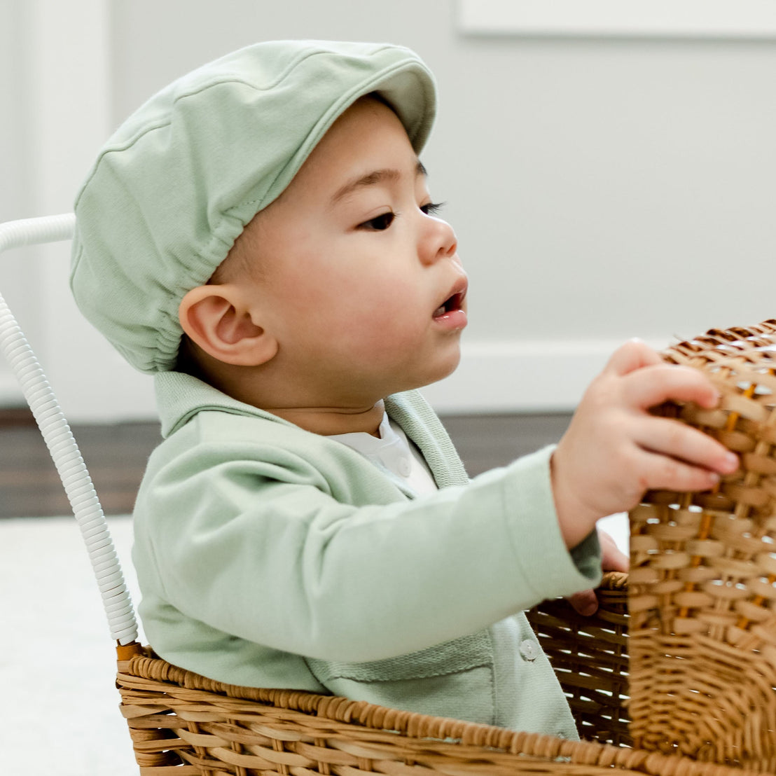 Boy in green newsboy cap in basket