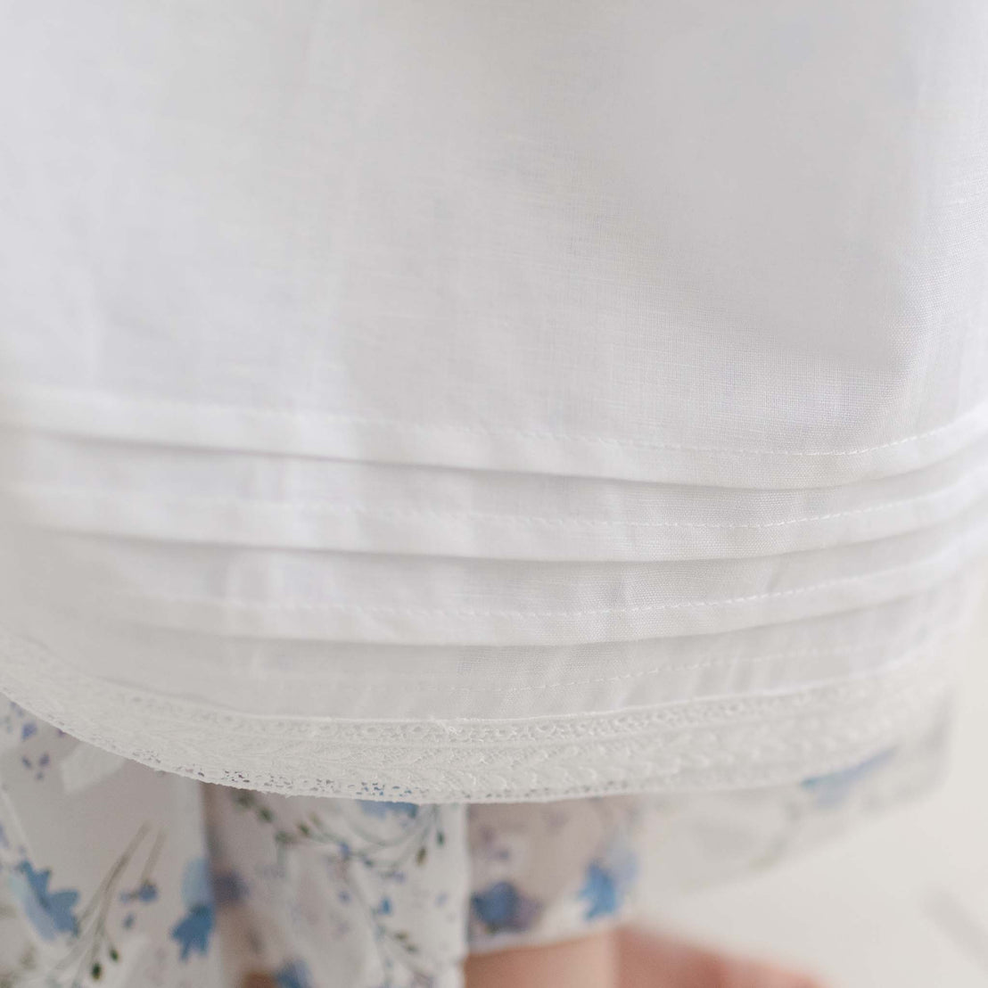 Flat lay photo of the ivory Oliver Convertible Skirt showcasing the hem detail on the white linen skirt.