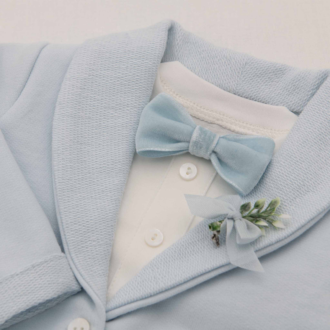 Flat lay photo of the Ezra Powder Blue 4-Piece Suit. Featured in the photo is the Blue Velvet Bow Tie and Boutonniere