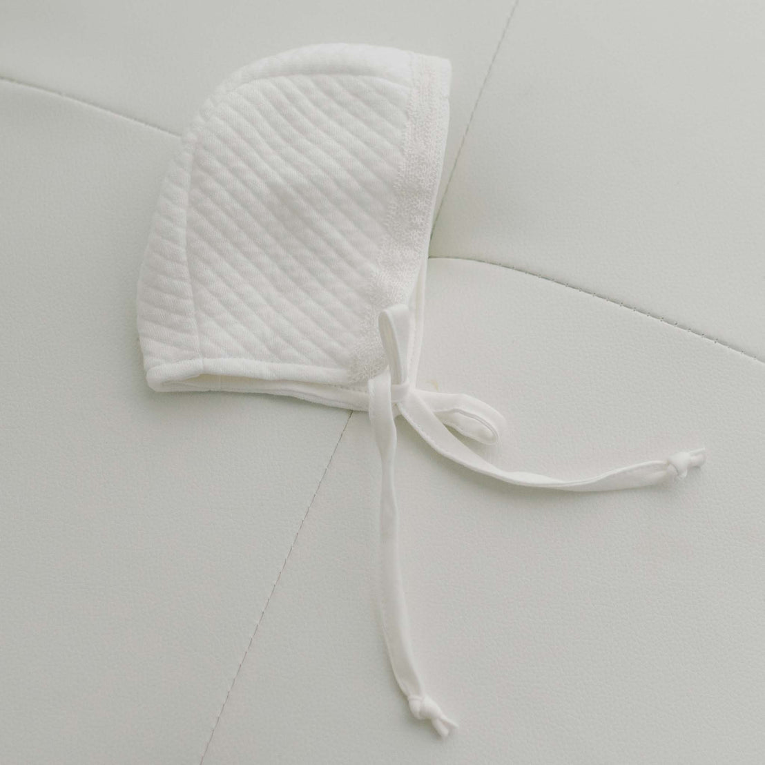 Side of ivory cotton baby bonnet