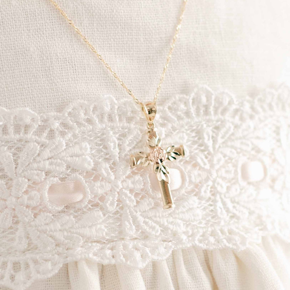 Rose gold rose on gold cross necklace on baby
