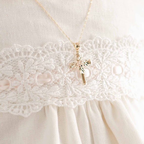 Rose gold rose on gold cross necklace on baby