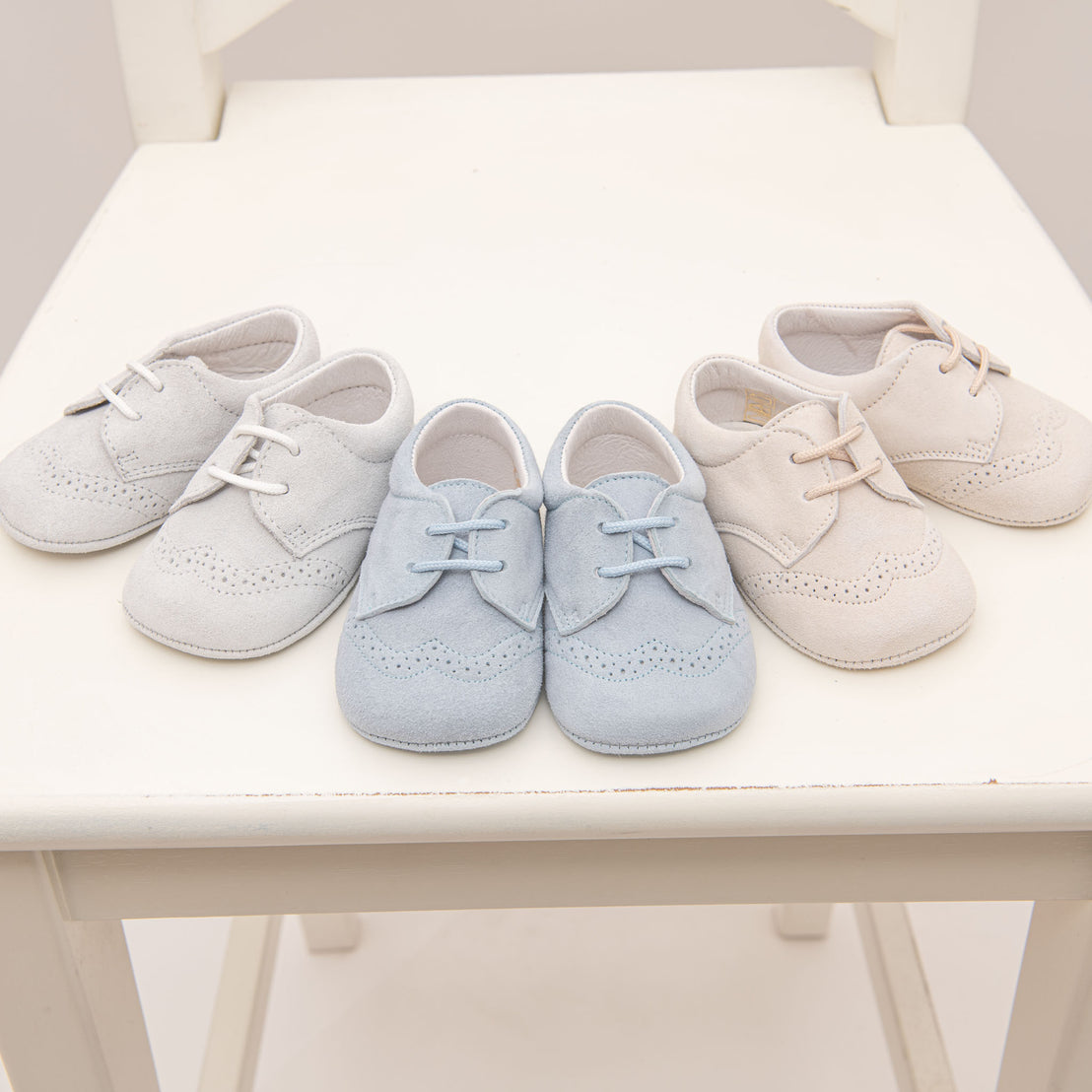 A photo of three pairs of Ezra Suede Shoes. These are available in three colors: tan, sky blue, and dove grey 