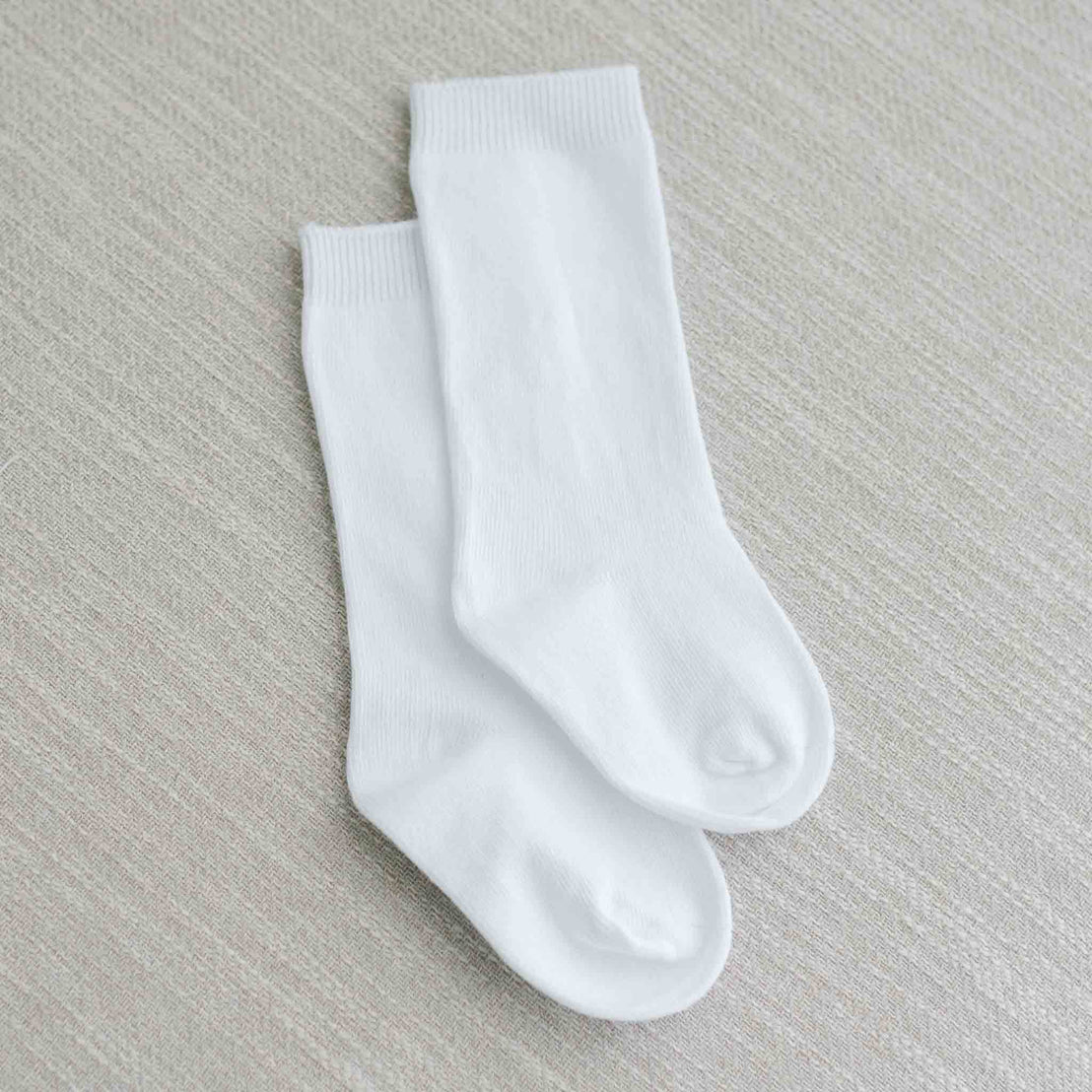 Flat lay photo of the Boys White Knee Socks made from cotton/nylon and spandex.