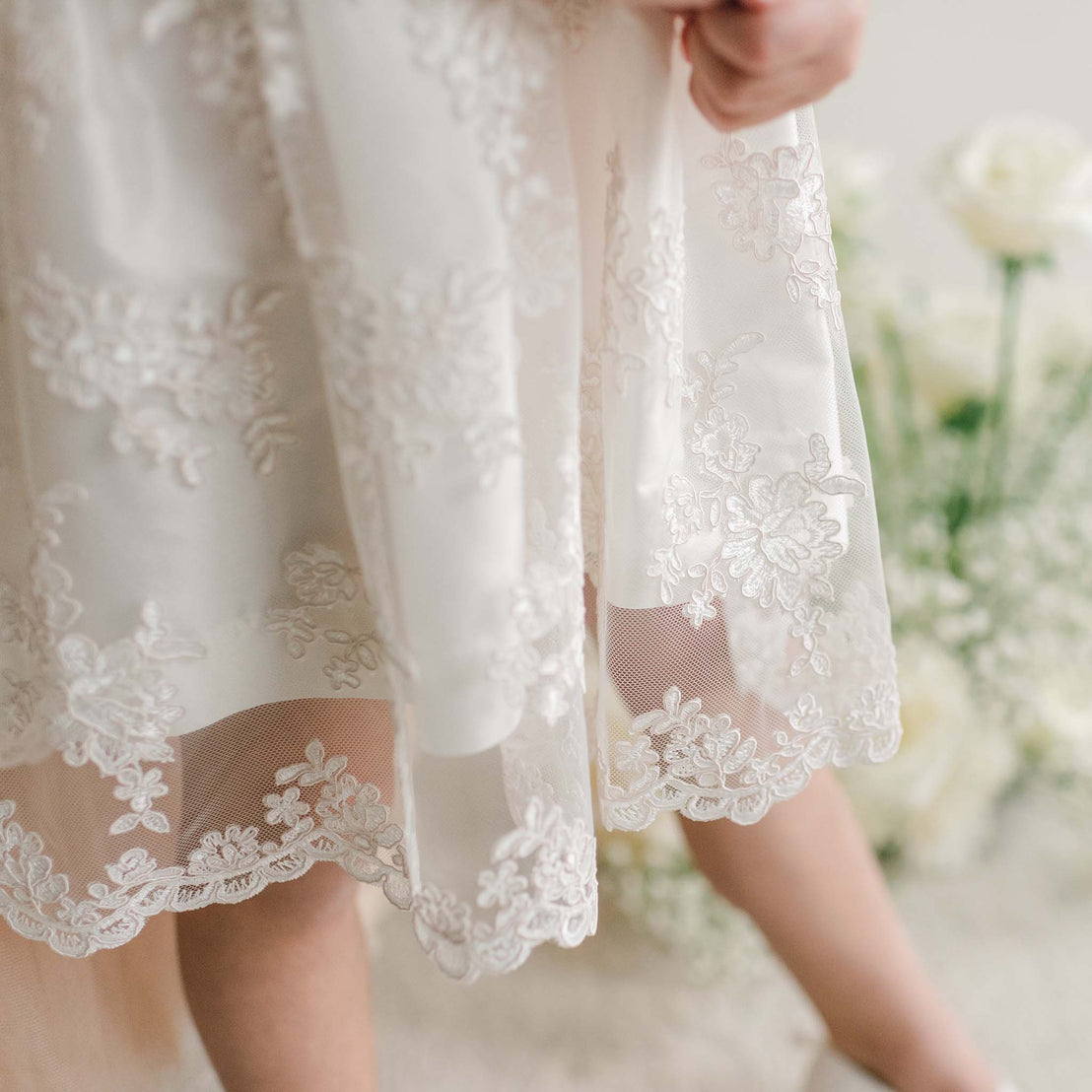 Detailed view of the Penelope Lace Dress skirt, showing the scalloped lace hem.