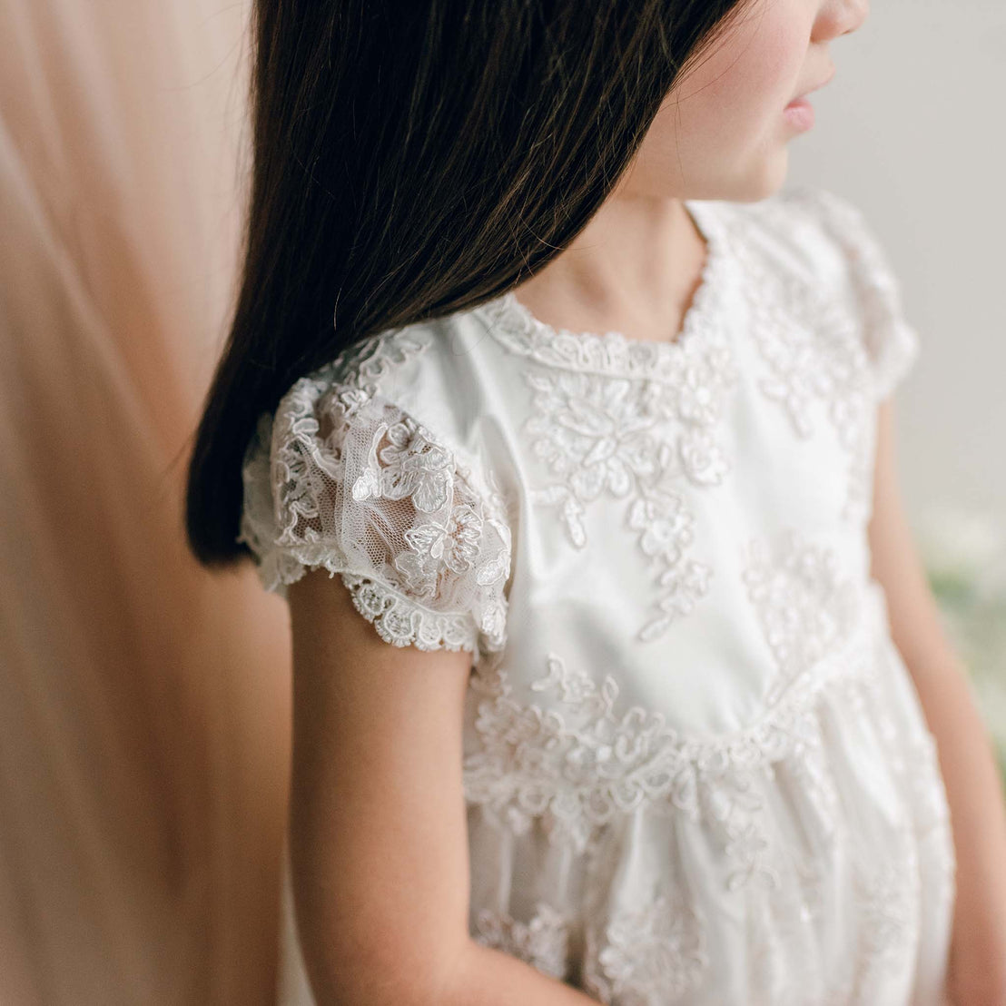 Side view of the Penelope Lace Dress sleeve and neckline, featuring intricate lacework.
