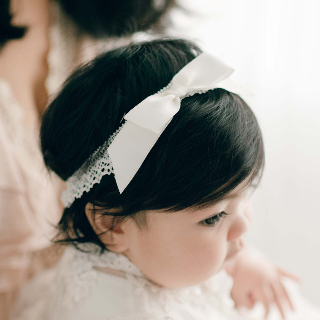 Baby headband lace and silk ribbon bow on baby girl with dark hair