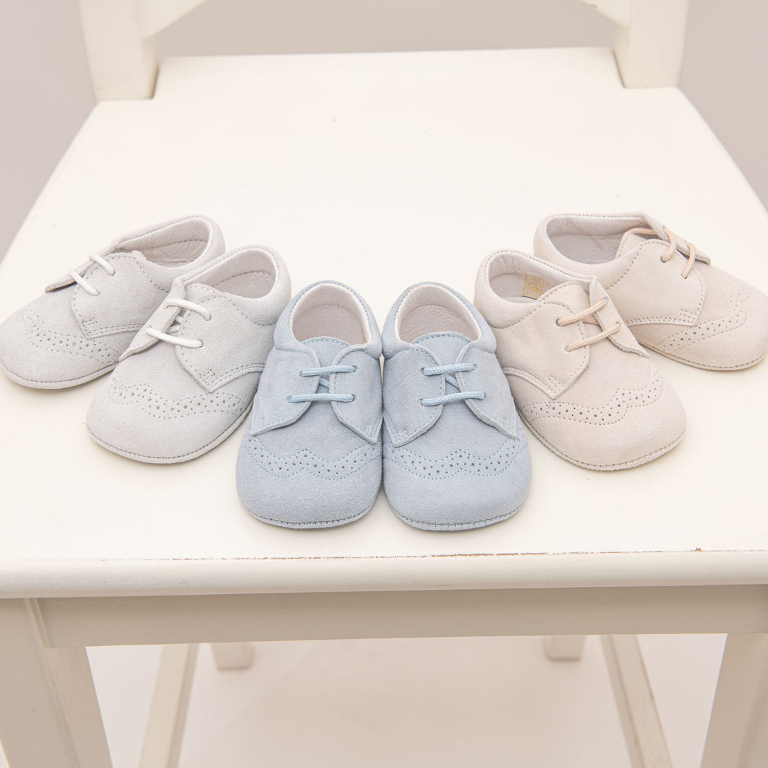 A photo of three pairs of Ezra Suede Shoes. These are available in three colors: tan, sky blue, and dove grey 