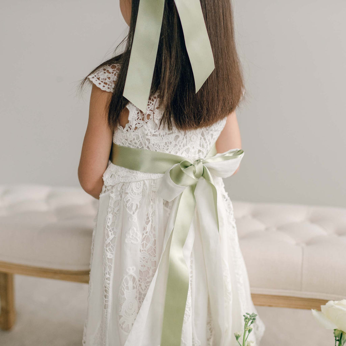Back view of the Grace Girls Lace Dress featuring the light green sash tied in a bow.