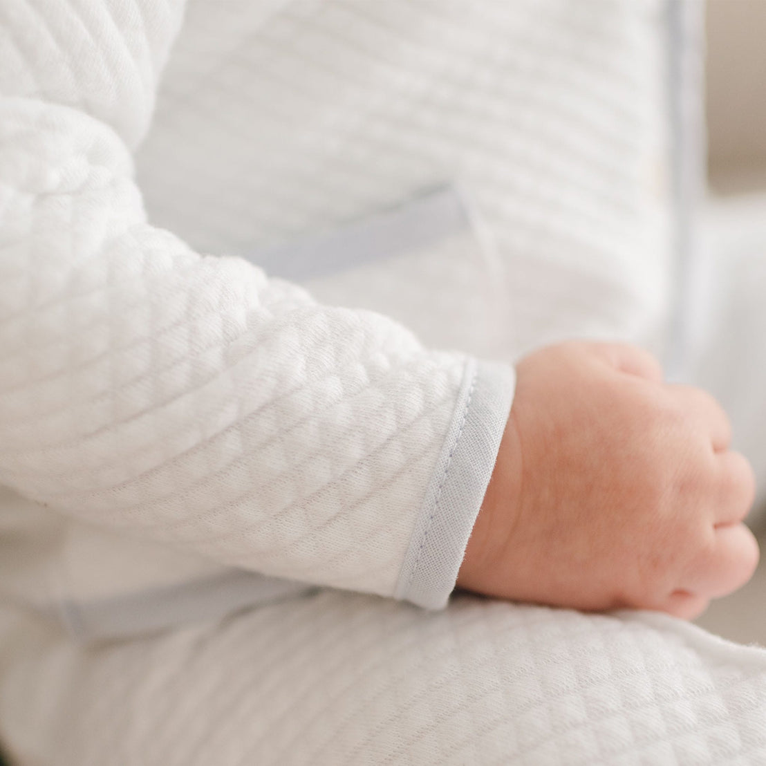 Close-up of the Harrison 3-Piece Suit’s sleeve, showcasing the quilted white fabric with light blue trim at the cuff and a soft, textured pattern.