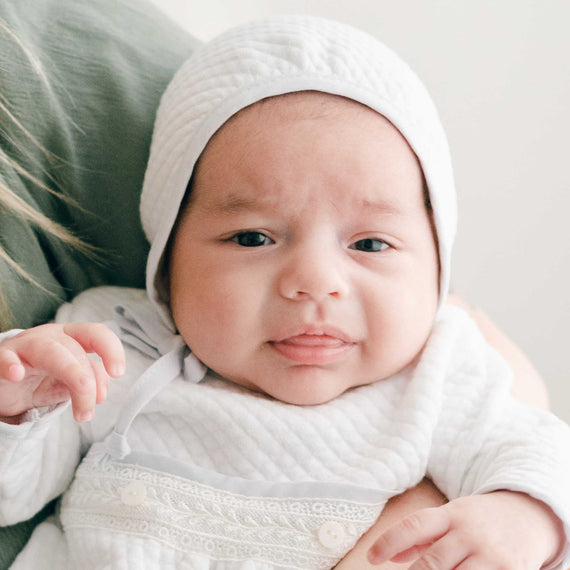 Close-up of a baby wearing the Harrison Quilted Bonnet, highlighting the soft quilted texture and snug fit.