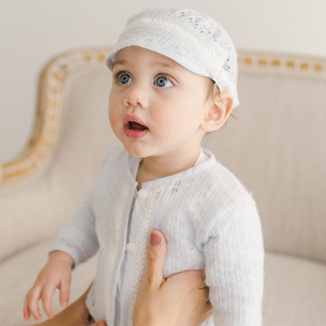 A baby gazing upward while wearing the Harrison Sweater 3-Piece Pant Suit, showing the delicate lace and button details.