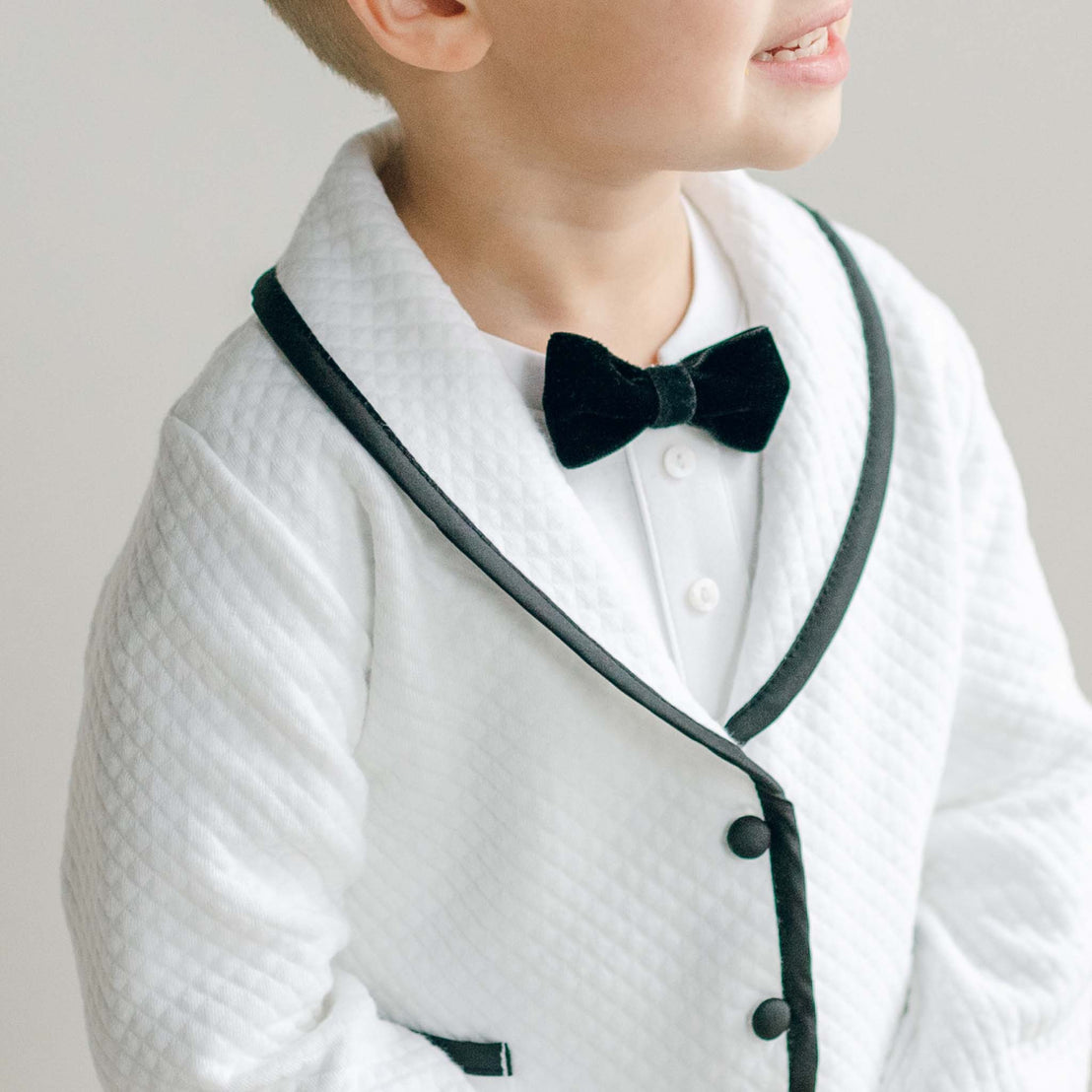 Close-up of the James 3-Piece Suit showing the white quilted jacket with black trim and black velvet bow tie.