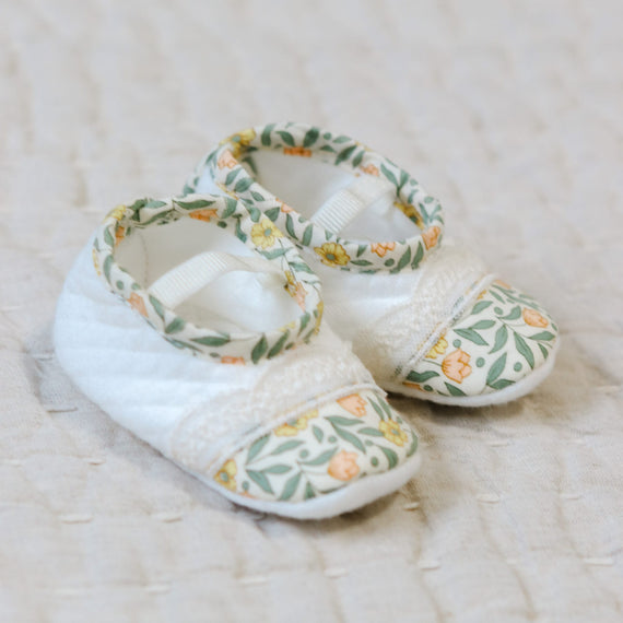 Flat lay photo of the Lillian Booties with yellow floral cotton trim. Set against a beige linen background.