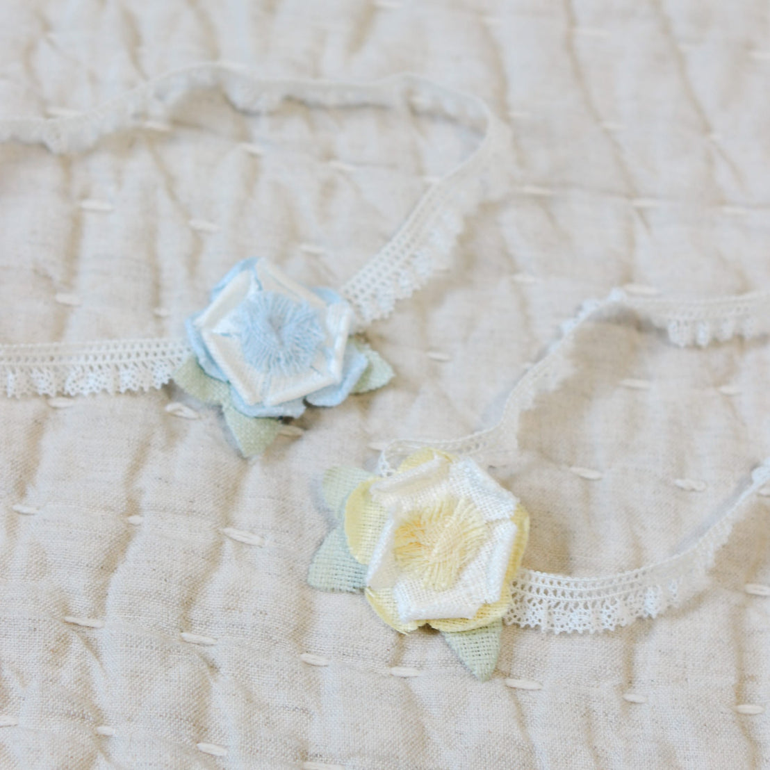 Close up flat lay photo comparison of the yellow and blue Lillian Linen Flower Headband. Details show a linen flower 