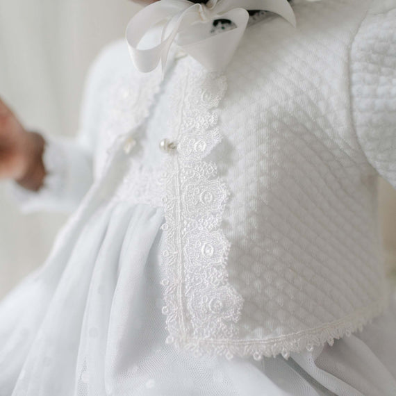 Close-up of a white quilted sweater with lace detailing