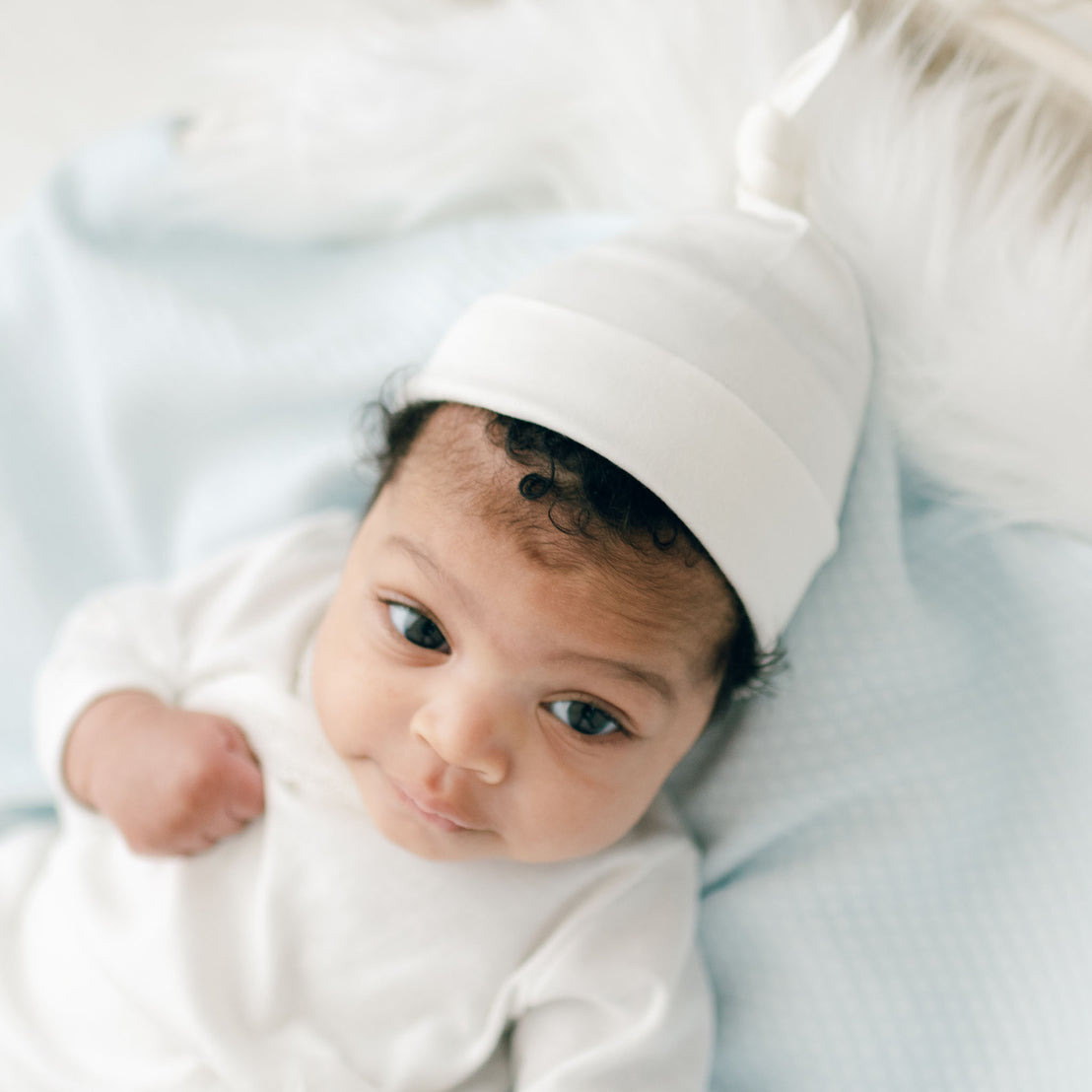 Baby girl wearing ivory cotton knot cap
