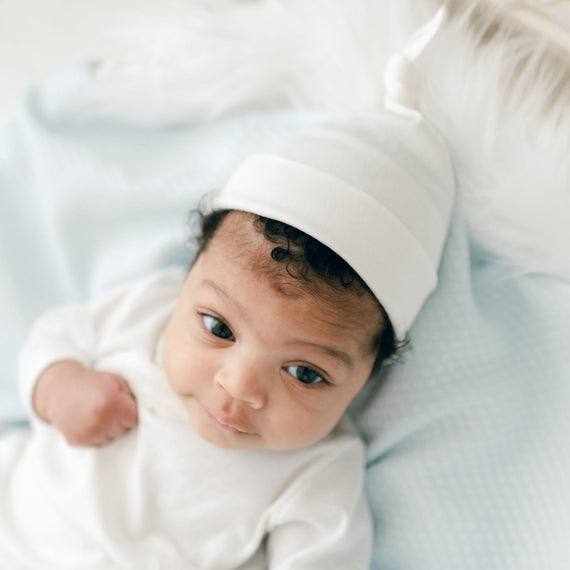 Baby girl wearing ivory cotton knot cap