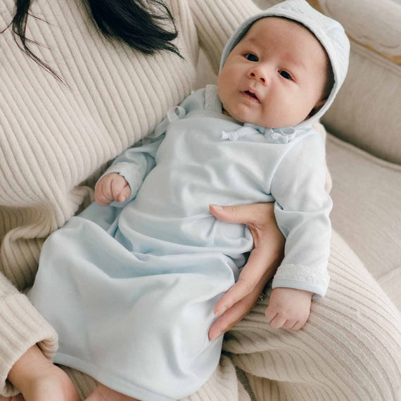 Baby with Mom, wearing blue pima newborn gown and quilted cotton bonnet