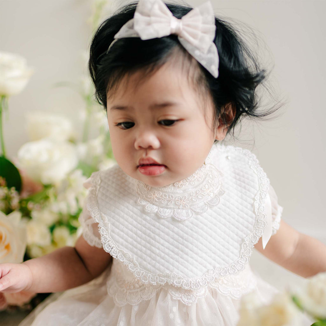 Sophia Bib with scalloped lace trim and quilted white fabric layered over a lace dress.