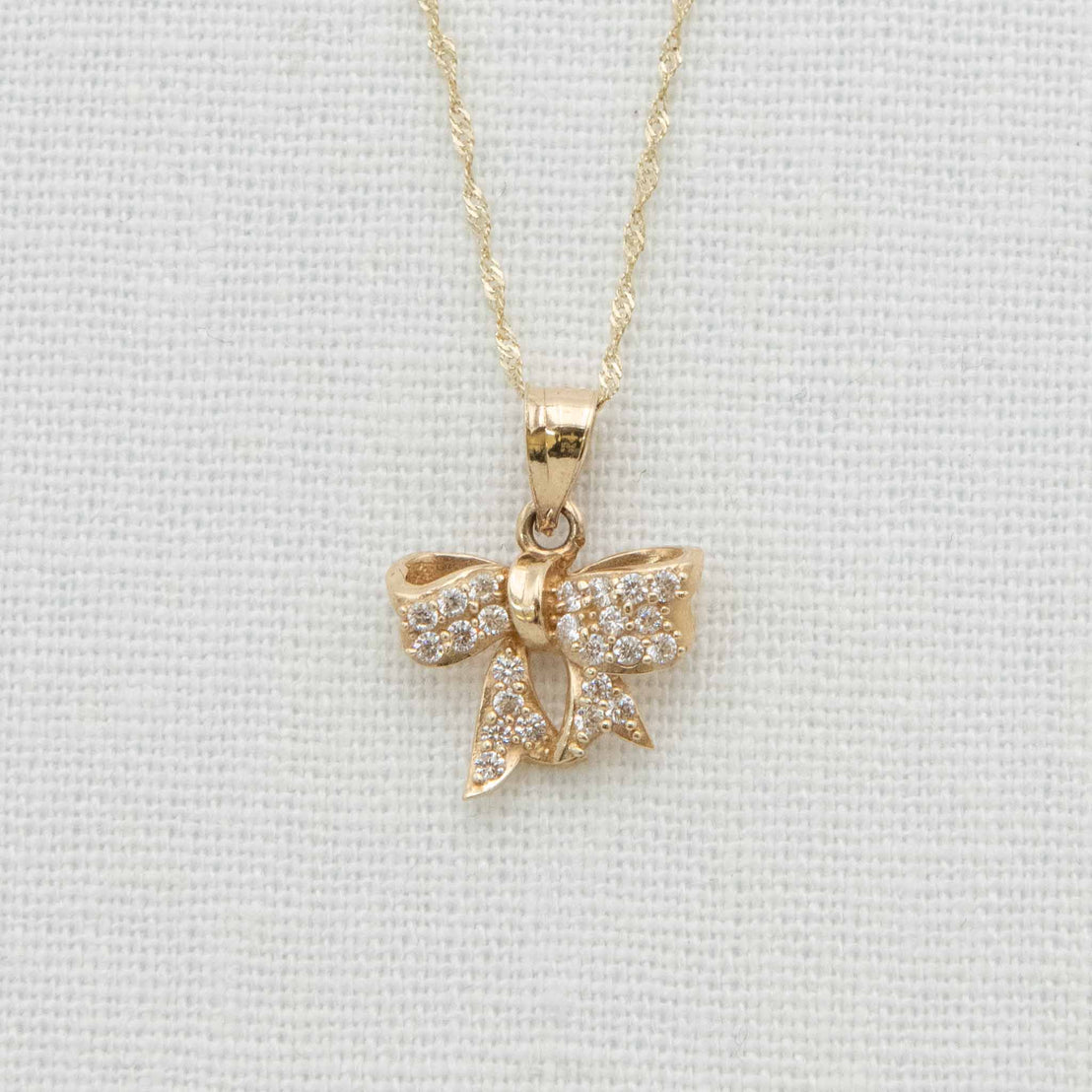 Solid gold bow charm with crystal details on chain