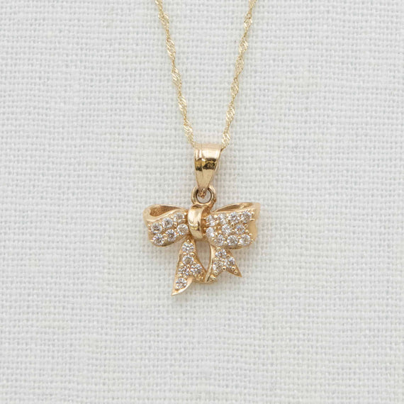 Solid gold bow charm with crystal details on chain