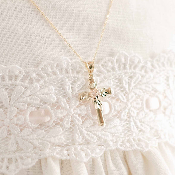 Rose gold rose on gold cross necklace on baby