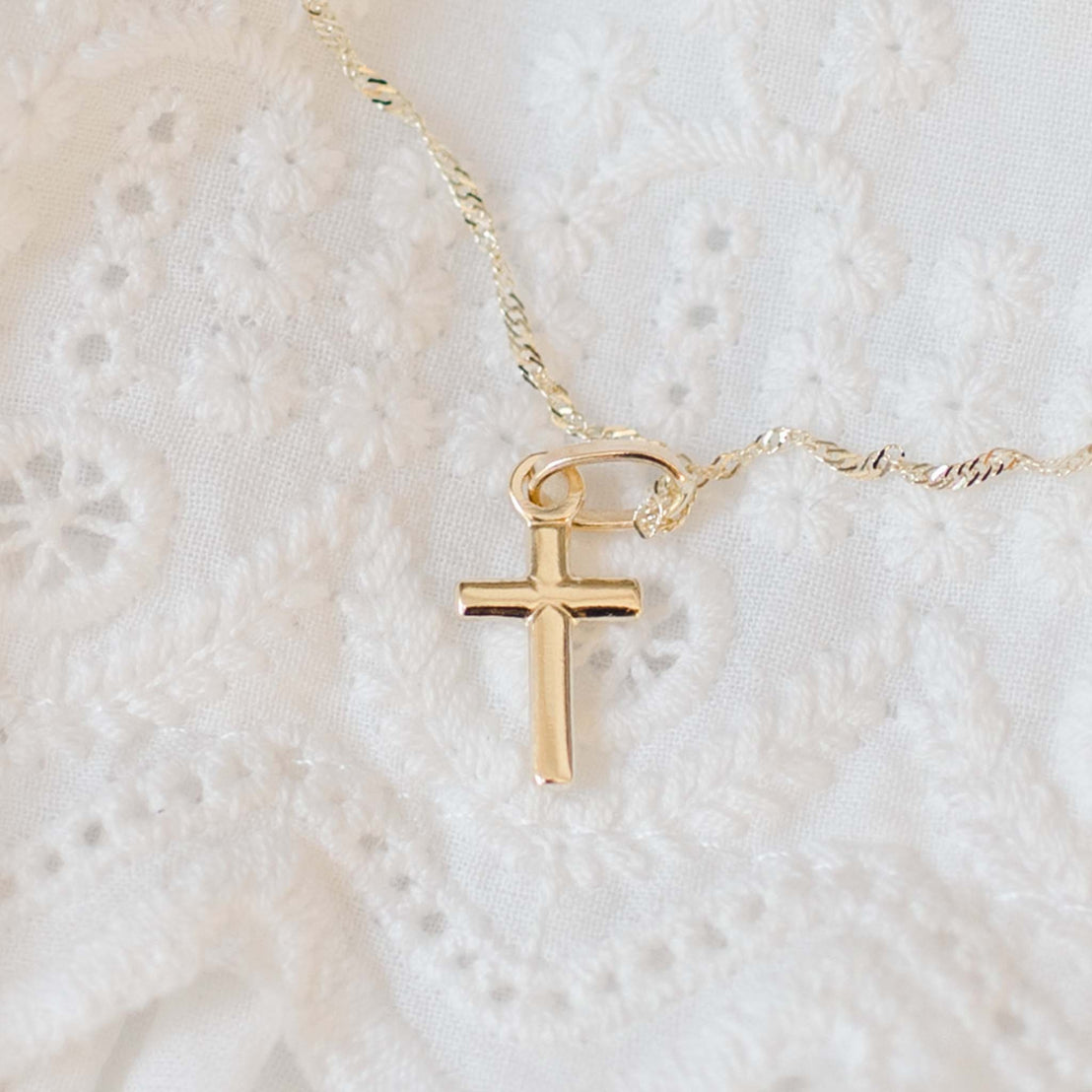 Tiny solid gold cross with tie detail on chain