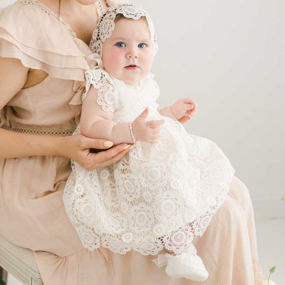 Photo of baby girl wearing her Poppy fancy baby dress in a photo session with her mom. 
