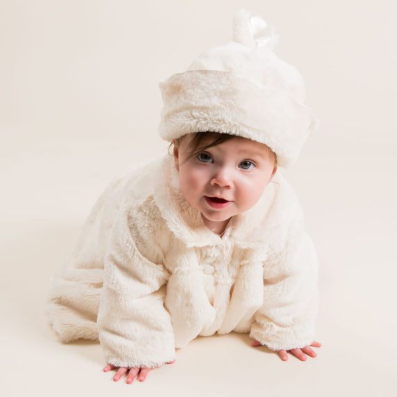 Dressed in the adorable Glad Dreams Coat Set, a baby crawls across a light background. Their playful expression and eyes fixed on the camera embody the charm of what could be the perfect unique baby gift.