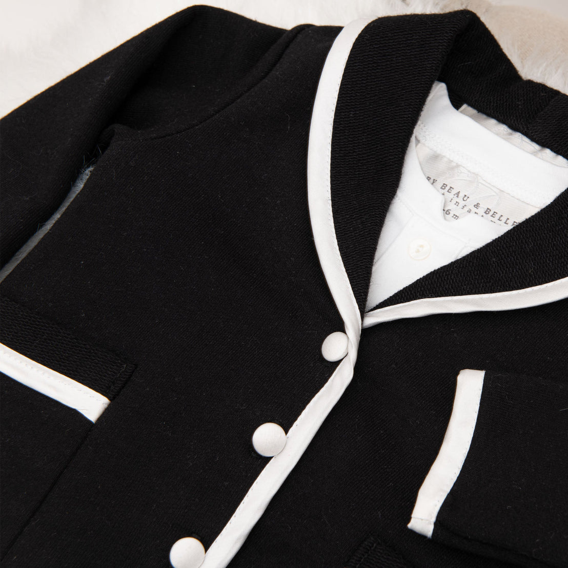 Detail of the black jacket from the James 3-Piece Suit, featuring white trim and buttons.