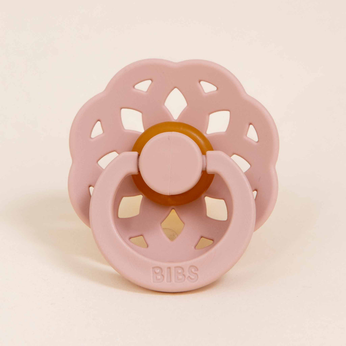 Front view of the blush pacifier from the Lola Pacifier Set, with a delicate petal-shaped design and soft silicone base.