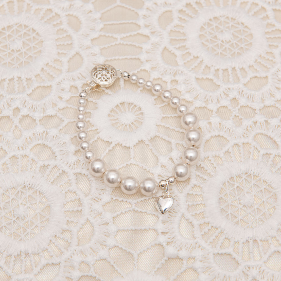 Baby jewelry bracelet with silver heart charm.