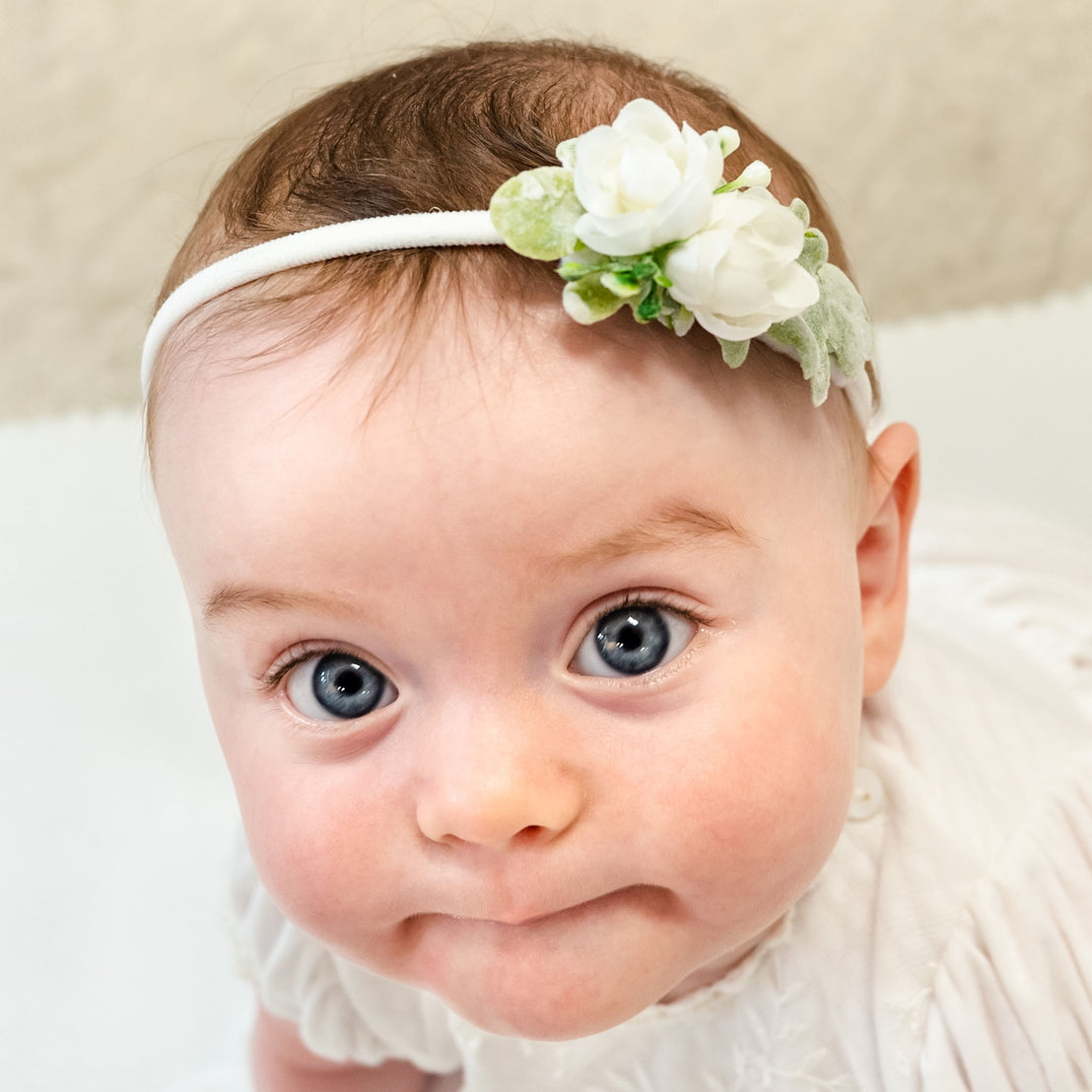 Baby girl looking into camera wearing the Ella petite flier headband 