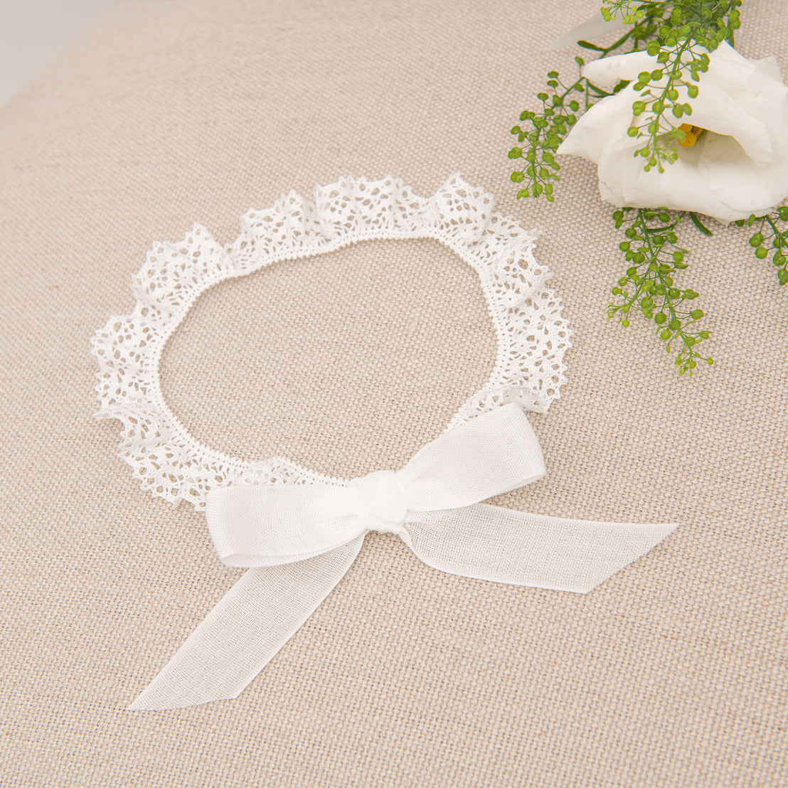Flat lay photo of a baby girl lace headband - part of our Poppy collection of upscale baby clothes.