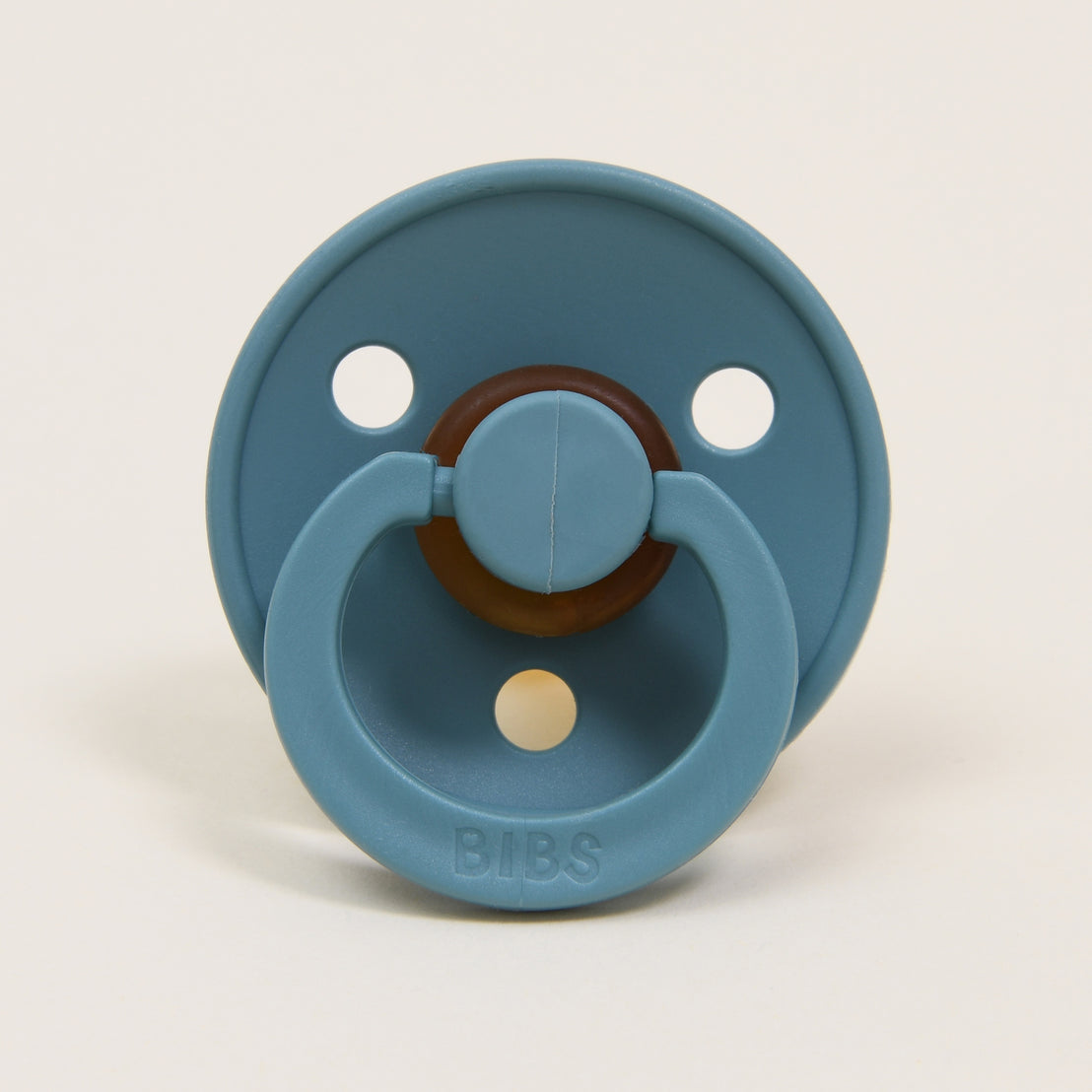 An island sea-colored Bibs pacifier set with a natural, circular handle.